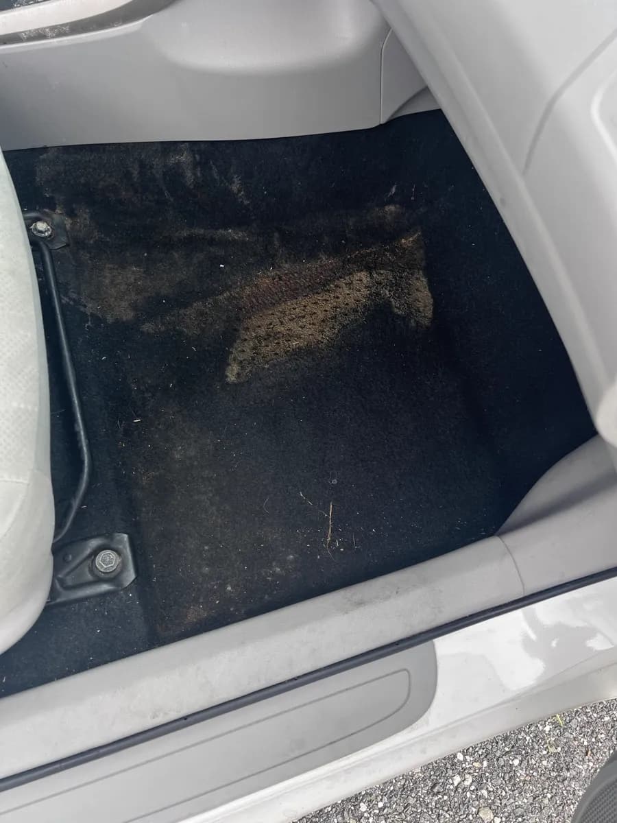 Driver side floor mat area — before